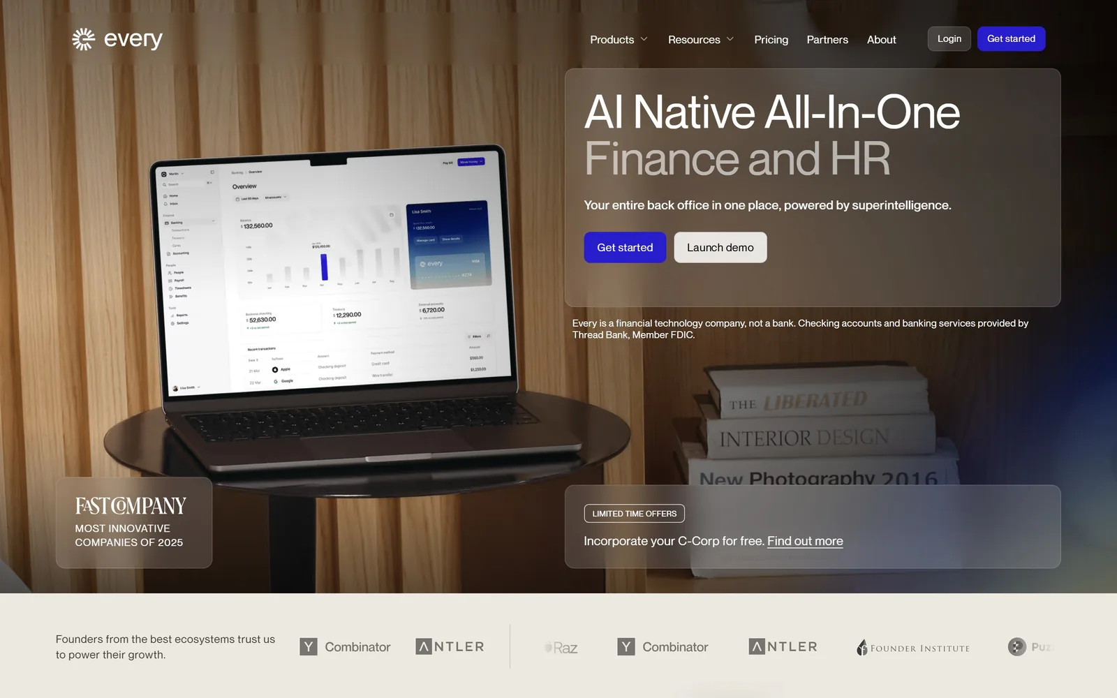 every.io, accounting website design: a laptop on a walnut table shot in warm light, with translucent frosted panels laid over the photograph