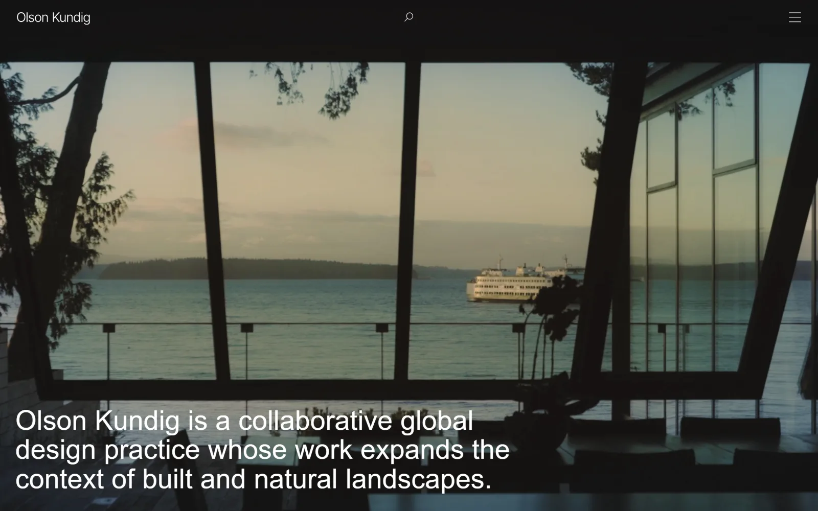 olsonkundig.com, architect website design: a dark video still looks out through a canted window wall at a ferry crossing grey water