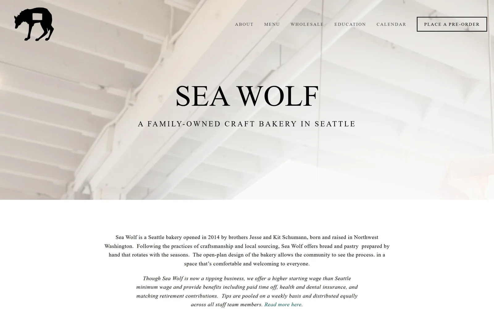 seawolfbakers.com, bakery website design: a black wolf mark over a pale photograph of painted ceiling joists