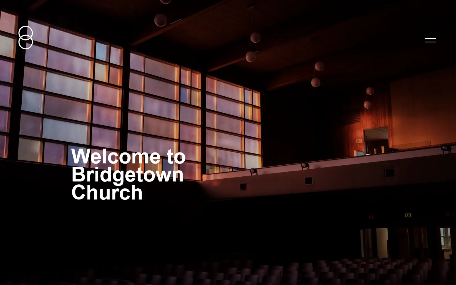 bridgetown.church, church website design: a dark auditorium with a wall of amber and lilac glass block