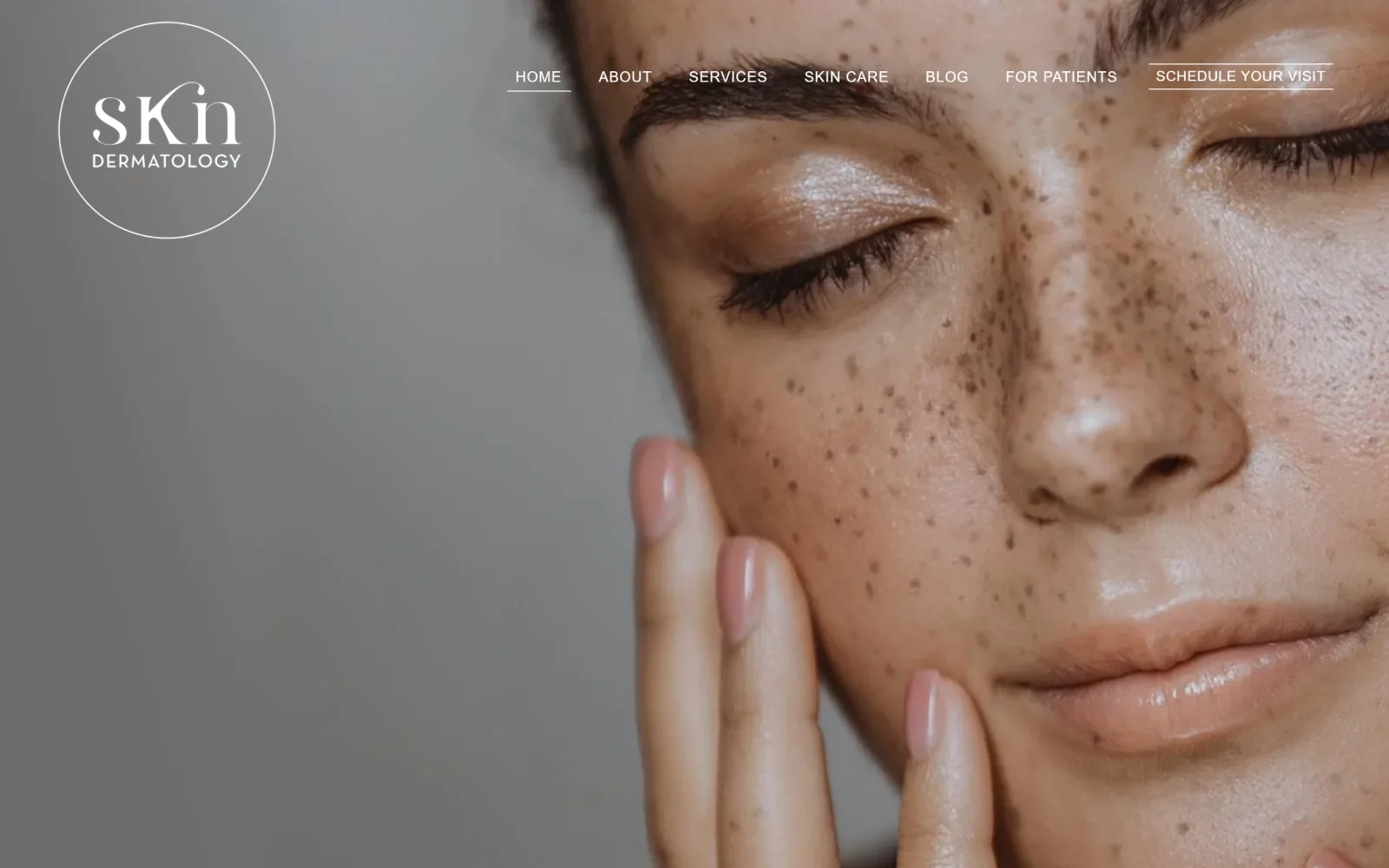 skndermatology.com, dermatology website design: a full-bleed close-up of a freckled face fills the frame