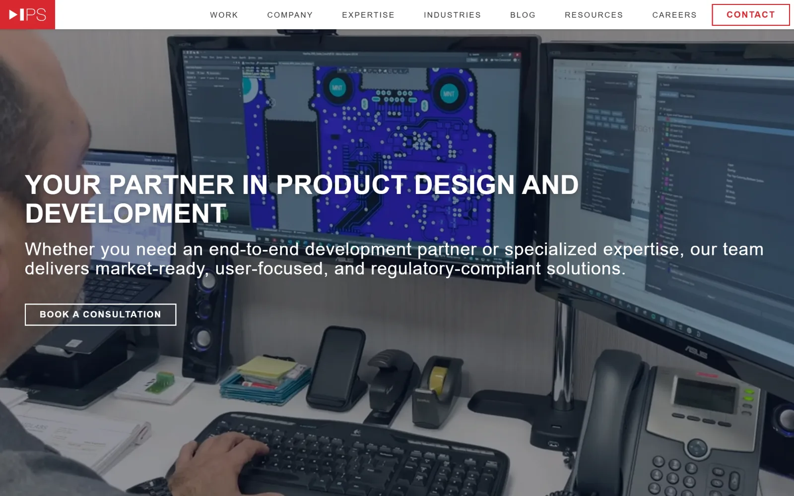 intelligentproduct.solutions, engineering website design: an engineer at a desk, a circuit board layout filling the monitor behind him