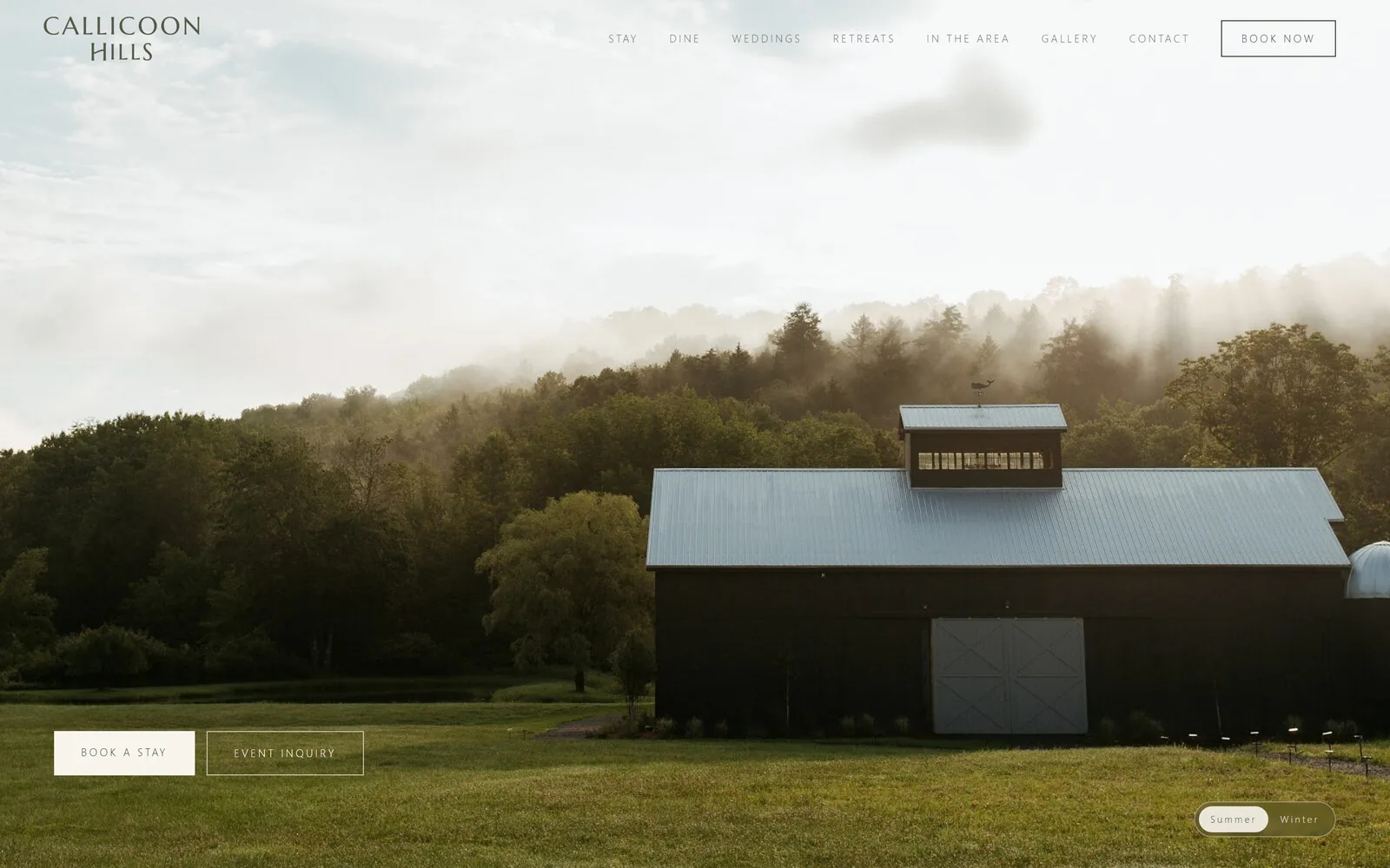 callicoonhills.com, hotel website design: a dark barn with a pale metal roof sits against fog-lit woods