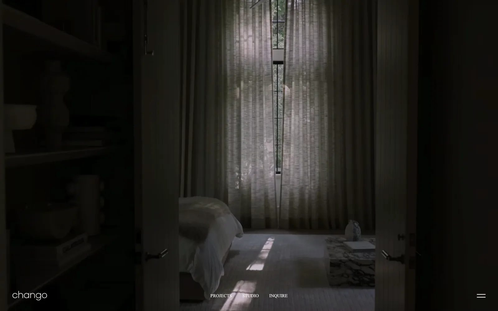 chango.com, interior design website design: a near-black bedroom seen through open doors, with the wordmark