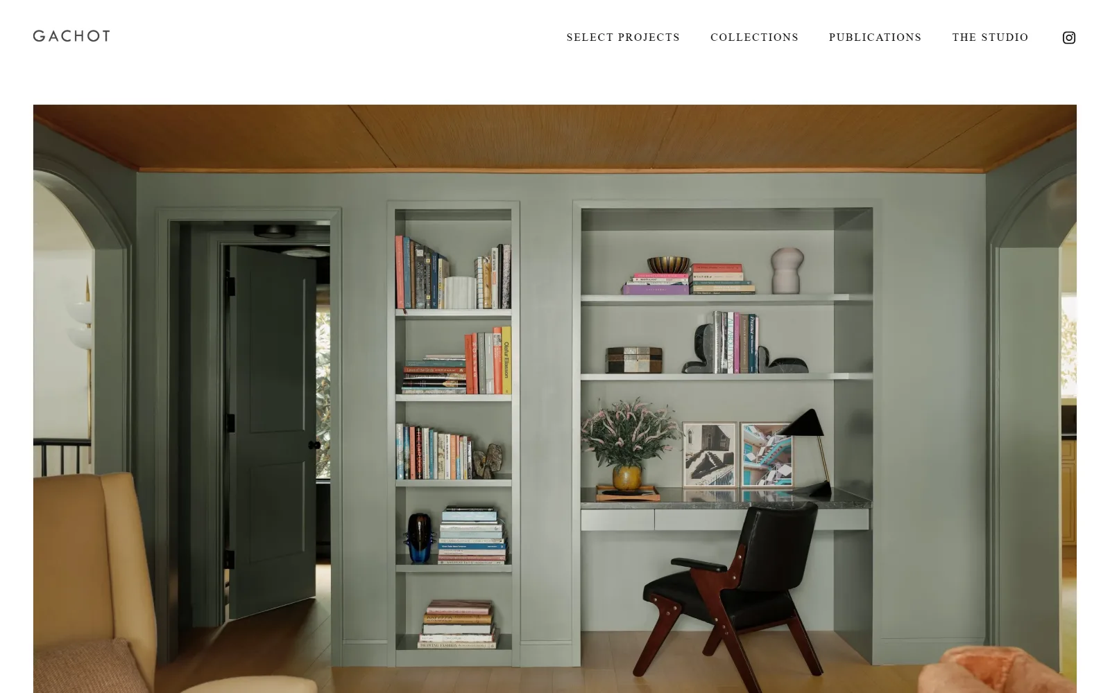 gachotstudios.com, interior design website design: a sage-green library with built-in shelves and a black leather chair