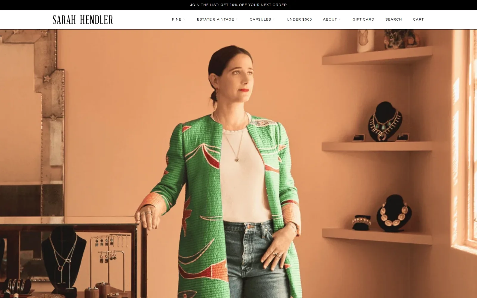 sarahhendler.com, jewelry store website design: peach walls, floating shelves of necklaces on black busts