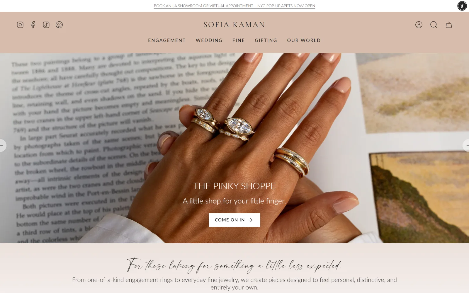 sofiakaman.com, jewelry store website design: three diamond rings on a hand resting over an open book about Seurat