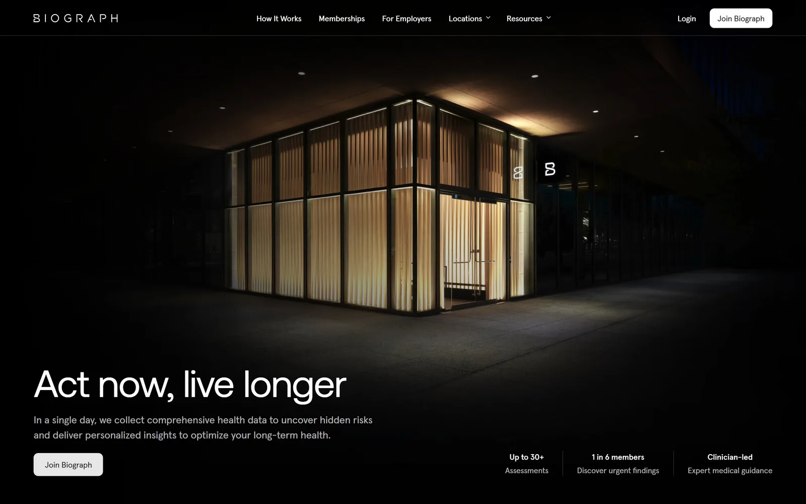 biograph.com, medical website design: the clinic photographed at night, a lit glass pavilion behind wood slats