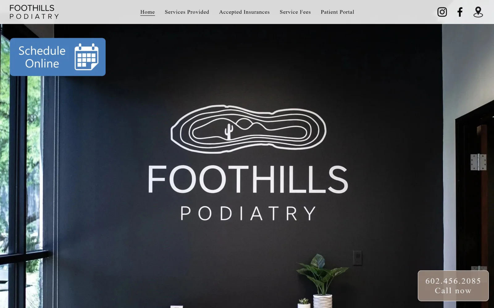 foothillspod.com, podiatry website design: a full-bleed photo of a near-black reception wall carrying the painted clinic logo