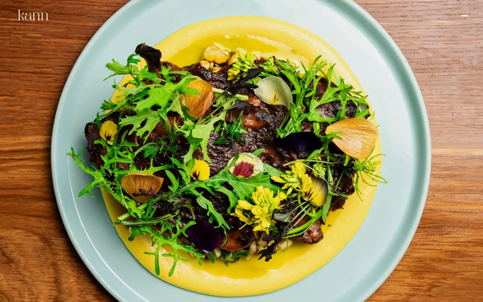 kannrestaurant.com, restaurant website design: one overhead plate shot fills the screen: charred meat and greens on pale yellow sauce