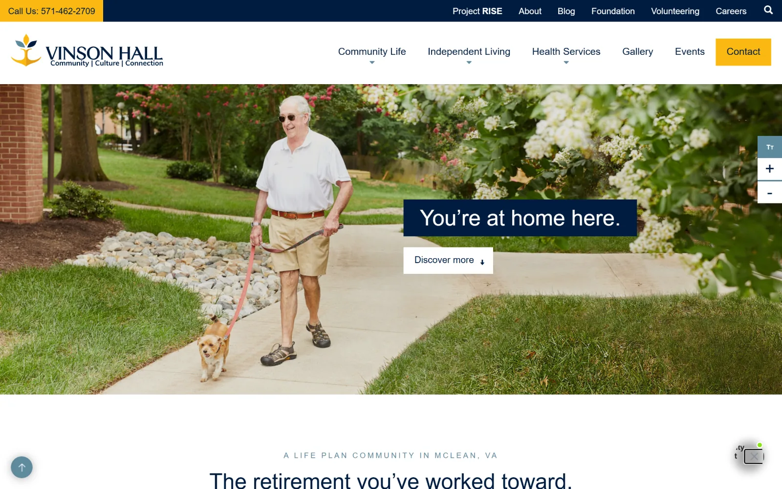 vinsonhall.org, senior living website design: a man walks a small dog along a campus path past flowering shrubs