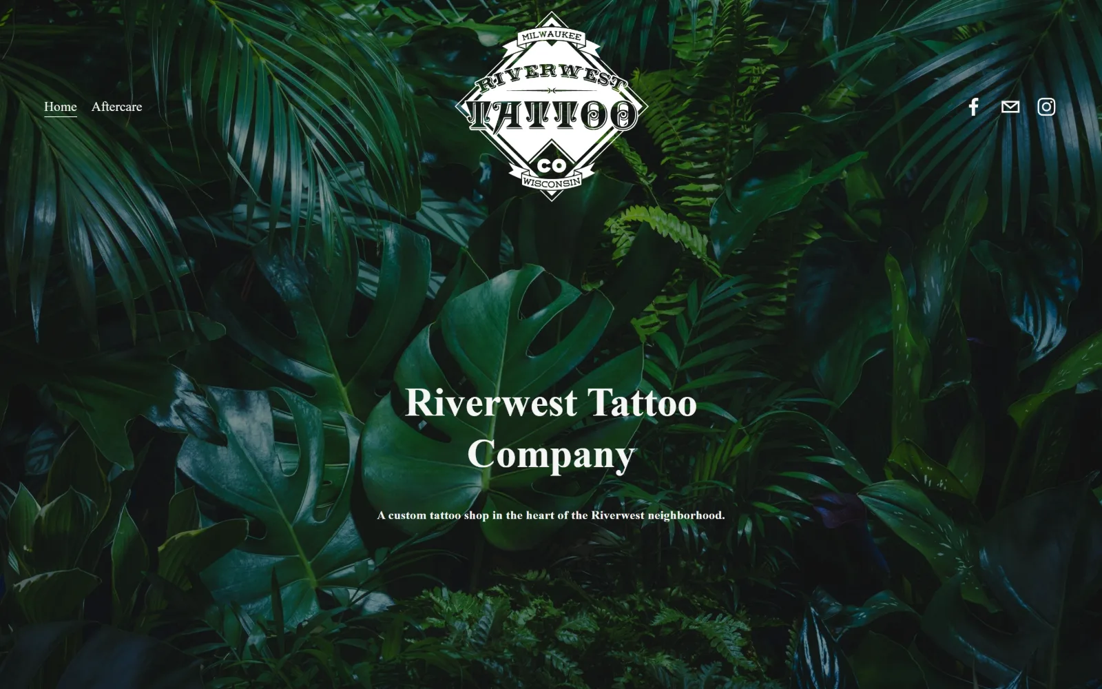 riverwesttattoocompany.com, tattoo website design: dense dark green foliage fills the frame, a white diamond badge sits at the top centre