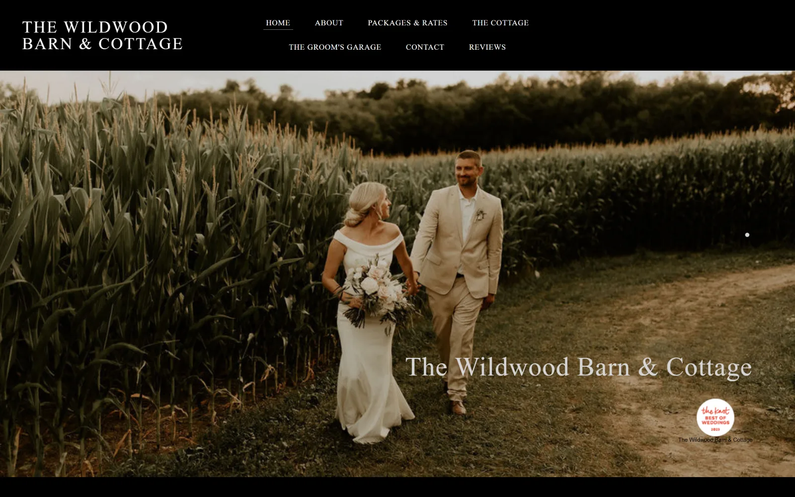 thewildwoodbarn.com, wedding venue website design: a couple walks a dirt track beside a tall corn field at dusk
