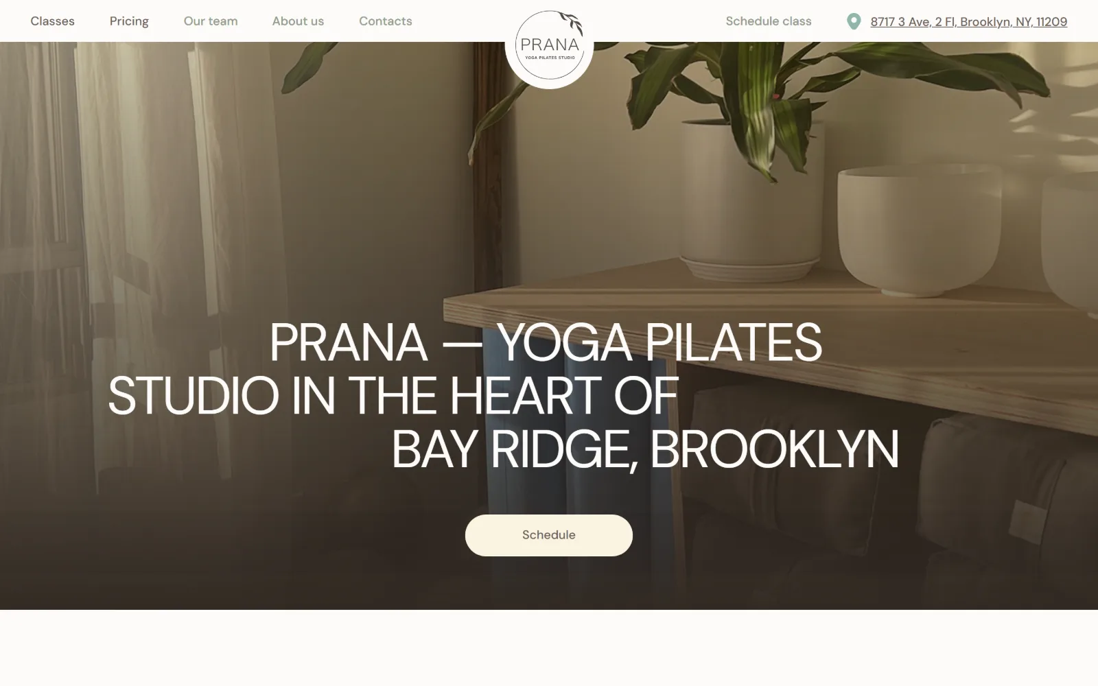 pranany.com, yoga studio website design: a sunlit corner with a potted plant, singing bowls on a timber shelf and rolled mats below